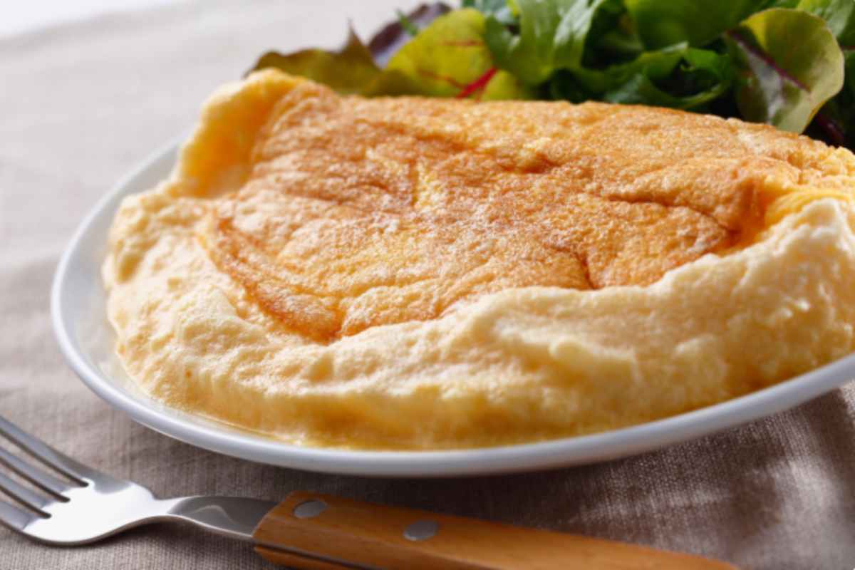 Frittata morbida con insalata in un piatto bianco