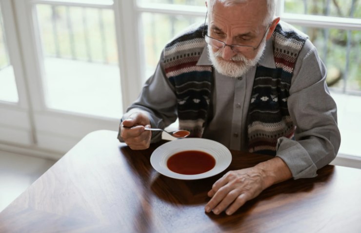 anziano che mangia da solo una zuppa