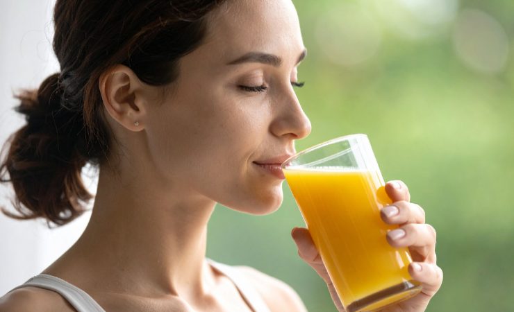 donna che beve spremuta d'arancia