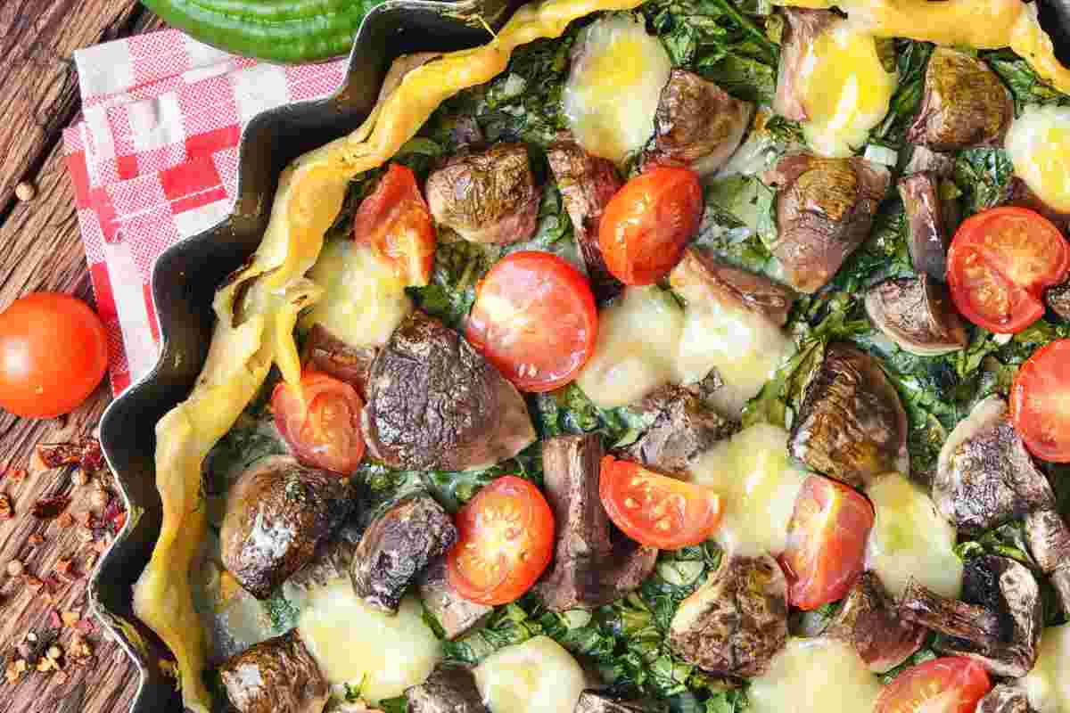 torta salata rustica funghi, spinaci e pomodorini vista dall'alto
