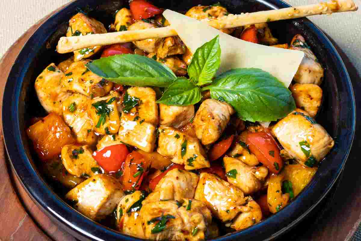 Dei bocconcini di pollo con peperoni in una padella