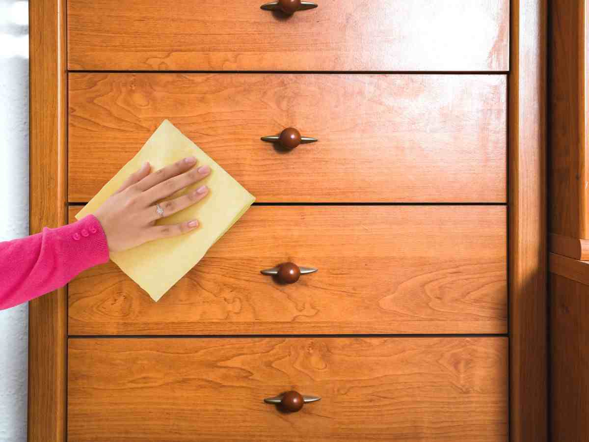 donna pulisce madia in legno