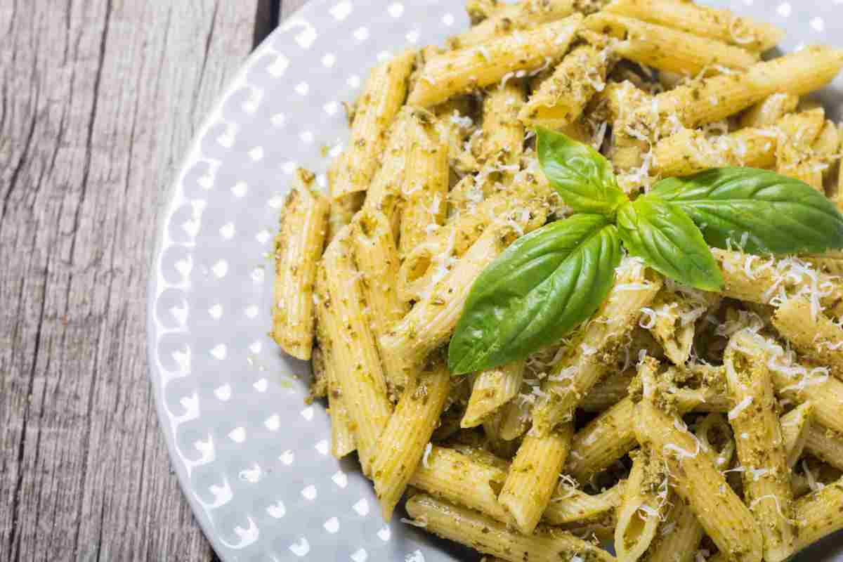 Pasta al pesto cremosa in un piatto su tavolo di legno
