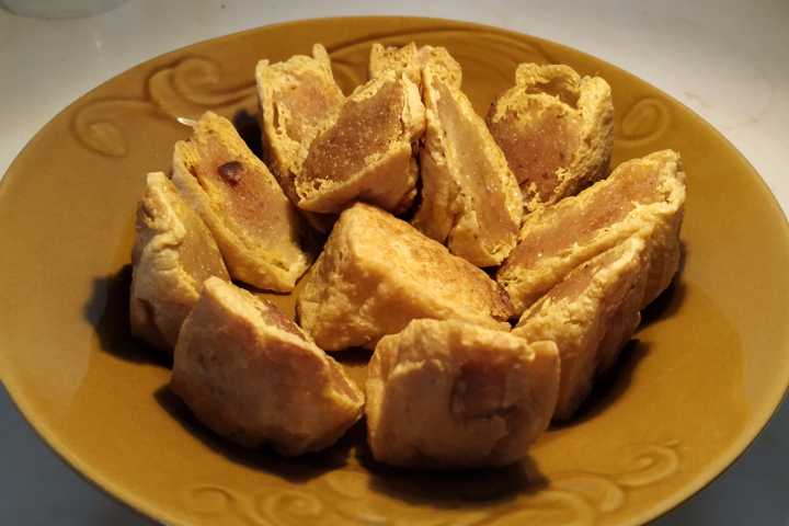 Dei cubotti di tofu imbottiti in un piatto marrone