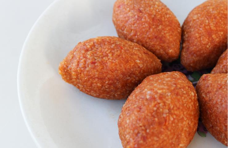kibbeh fritti con granella di pistacchio in un piatto