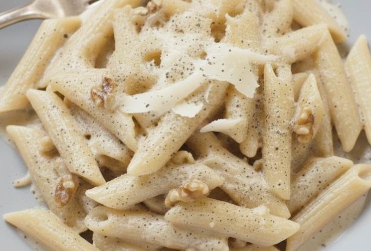 primo piano di penne con crema di noci panna e parmigiano