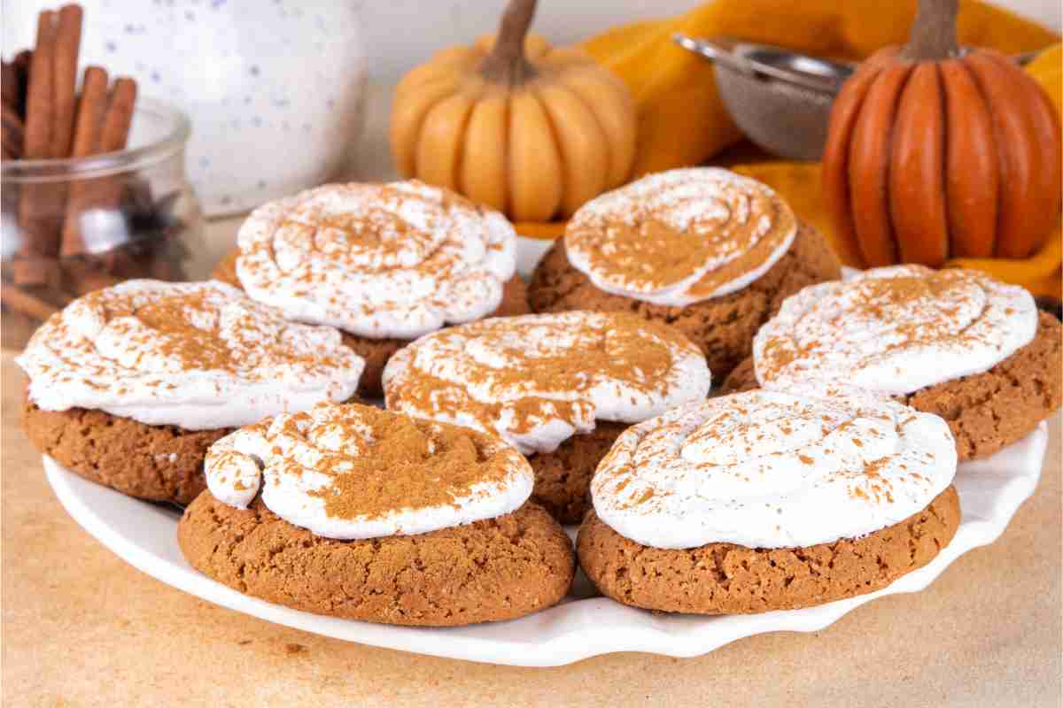Biscotti alla zucca con frosting al formaggio spalmabile su un tavolo