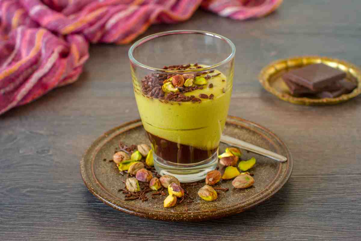 Mousse al Pistacchio e Cioccolato in un bicchiere su piattino con pistacchi tritati