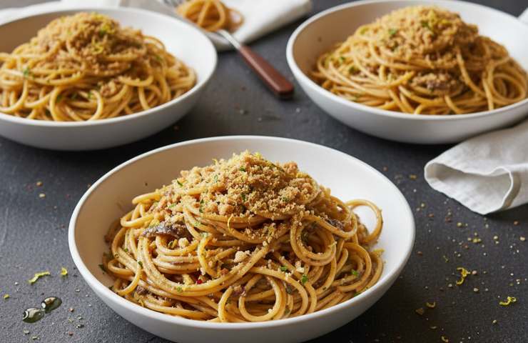 Spaghetti con Alici e Mollica in tre piatti bianchi