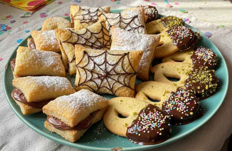 Mascherine di Carnevale e dolcetti assortiti in un piatto ampio