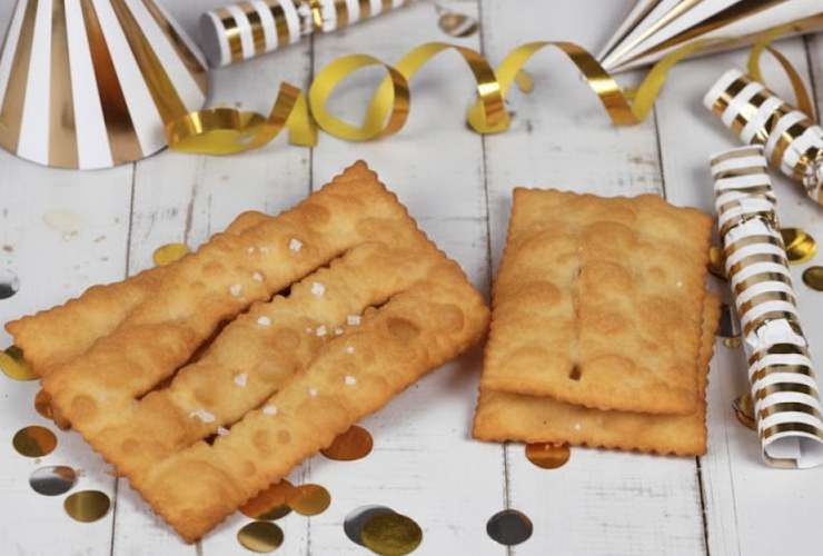 chiacchiere dorate e salate su tavolo di legno