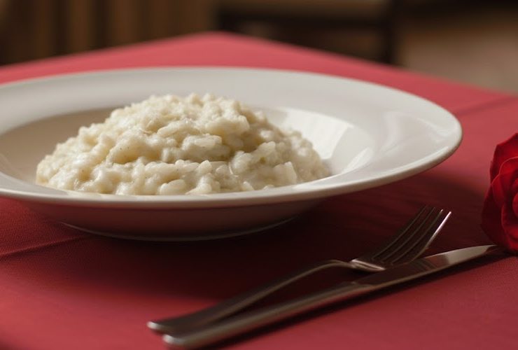 piatto di risotto allo champagne su tavolo con tovaglia rossa