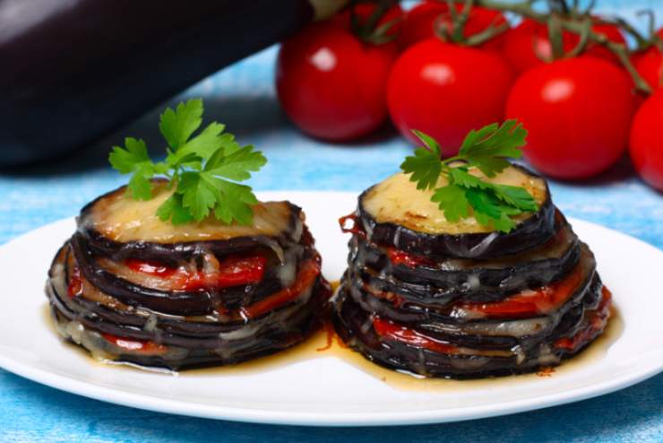 torrette di melanzane e pomodori in piatto bianco