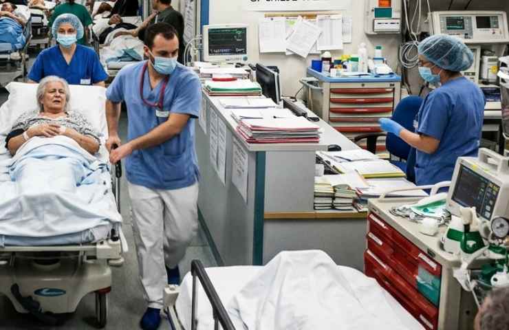 Scena in un ospedale al pronto soccorso con medici che soccorrono dei pazienti in corridoio.