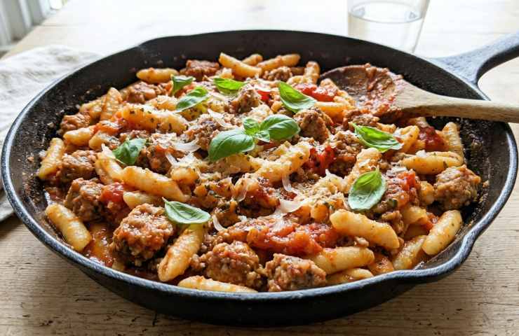 Cavatelli cremosi con salsiccia e pomodoro saltati in padella di ghisa con basilico fresco.