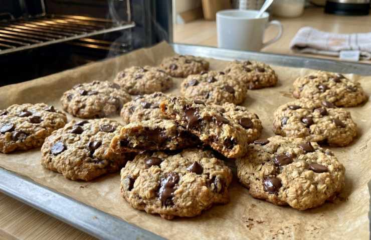 Teglia di biscotti nuvola banana e cioccolato appena sfornati su carta forno, ricetta sana 3 ingredienti senza burro e senza farina.