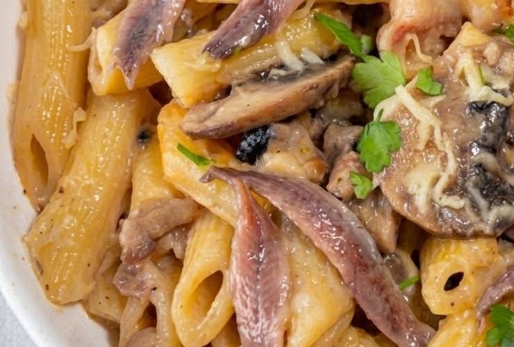 piatto di pasta con funghi e acciughe