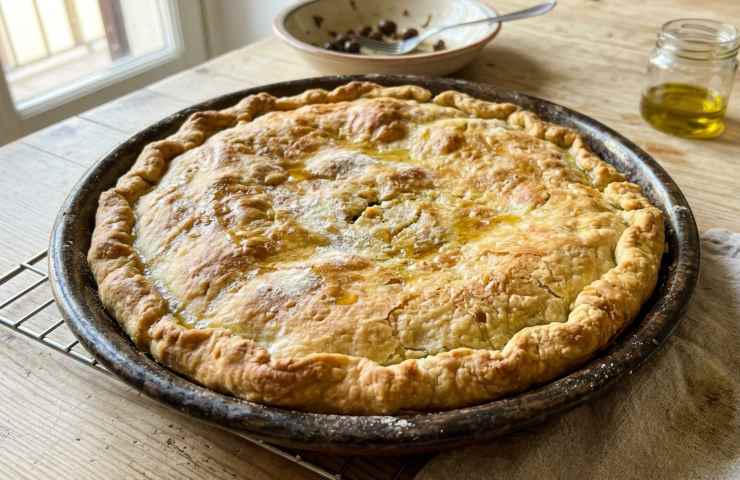 Tiella di scarola intera appena sfornata su griglia di raffreddamento, ricetta rustica tradizionale per il Venerdì Santo.