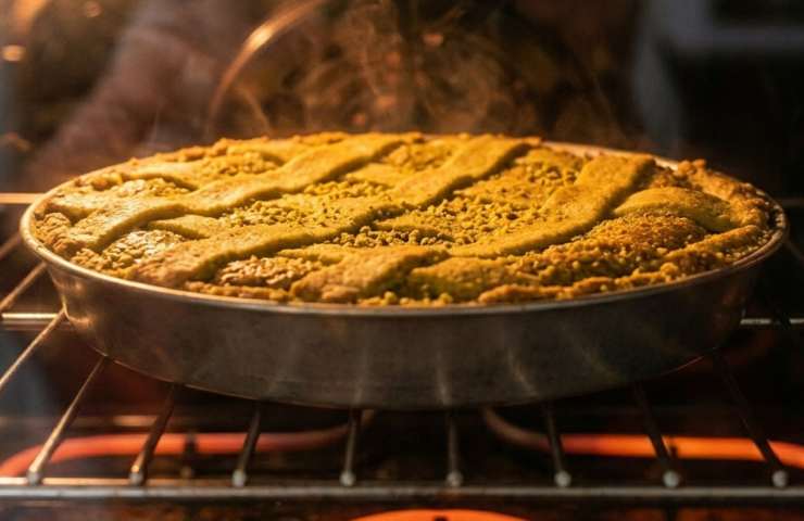 Pastiera al pistacchio intera in teglia circolare da forno: la torta pasquale completa con griglia di frolla perfetta e ripieno verde al pistacchio.