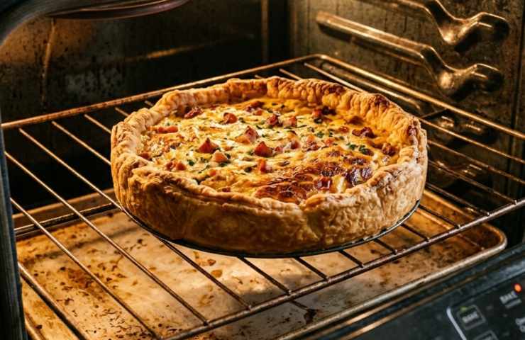 Quiche di Pasquetta in forno negli ultimi minuti di cottura: pasta brisée dorata e ripieno gonfio su griglia.