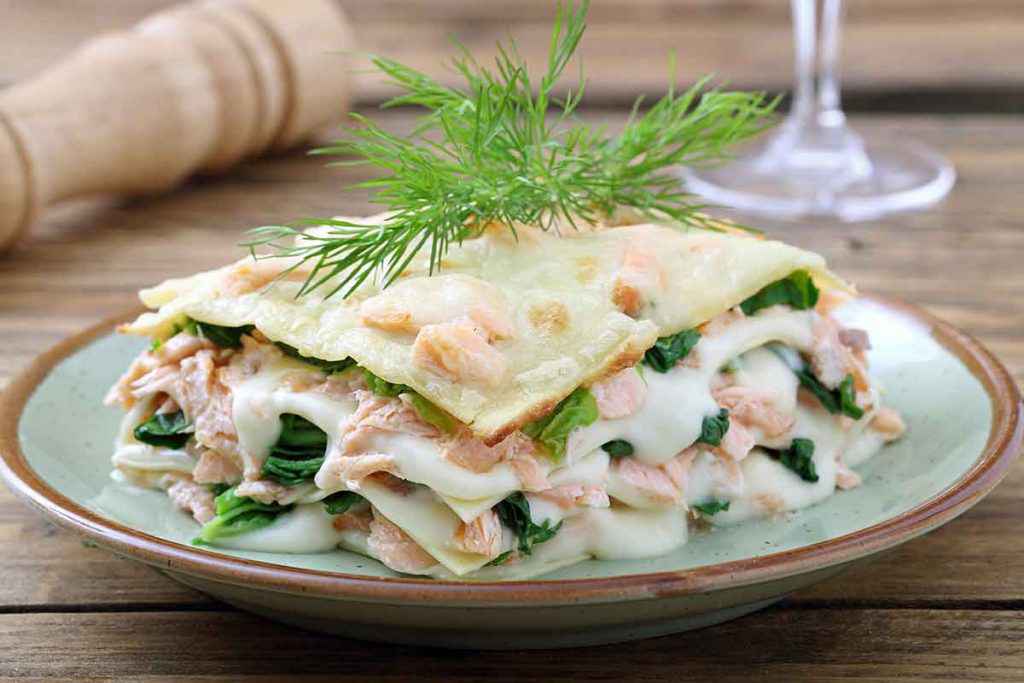 Piatto di lasagna con salmone fresco e verdure