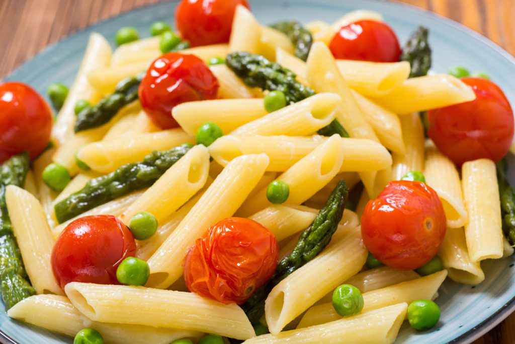 Pasta primavera fredda con pomodori, asparagi e piselli