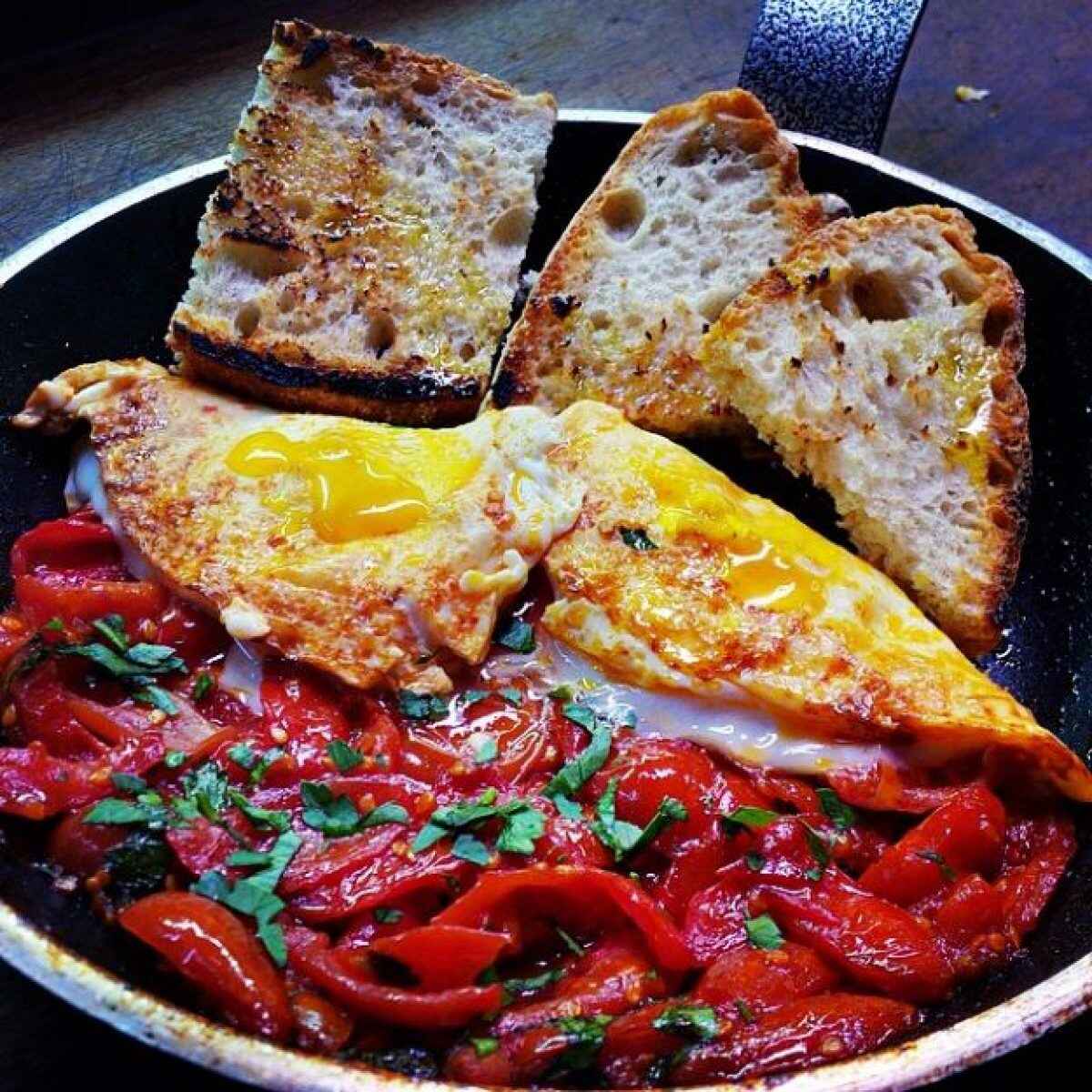 Uova al tegame con peperoni e pomodori